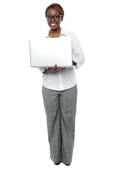 Full length portrait of female business secretary working on laptop