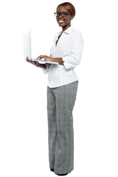 African businesswoman working on laptop. Full length portrait
