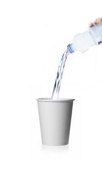 pouring water from a plastic bottle isolated against white background