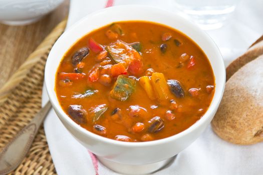 Minestrone soup [Zucchini,aubergine,bean,pepper and carrot in tomato soup ] by a loaf of bread