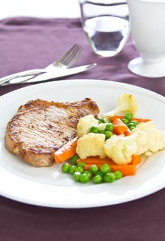 Pork steak with sautéed pea,cauliflower and carrot