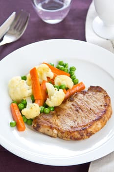 Pork steak with sautéed pea,cauliflower and carrot