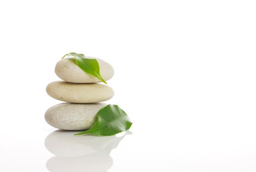 Spa stones and green leaf, isolated on white background.