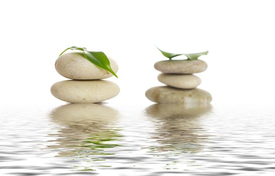 Spa stones and green leaf, isolated on white background.