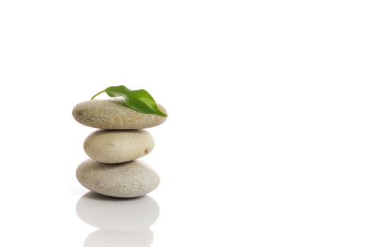 Spa stones and green leaf, isolated on white background.