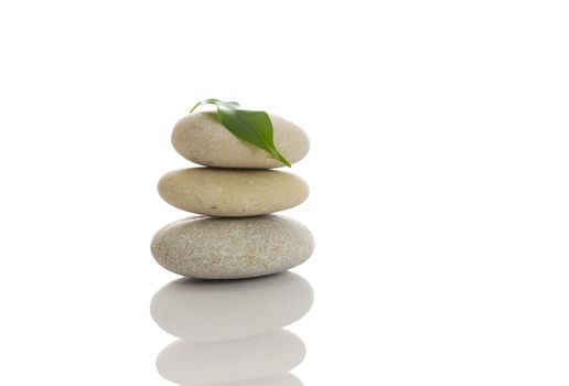 Spa stones and green leaf, isolated on white background.