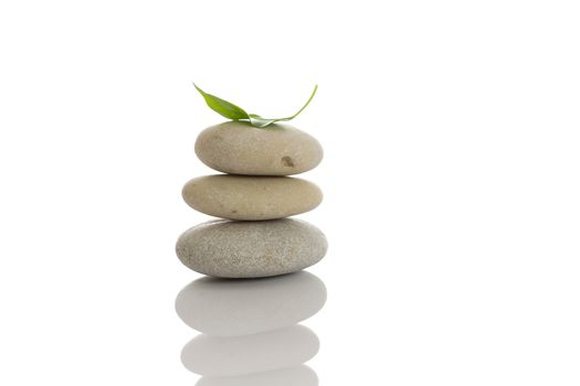 Spa stones and green leaf, isolated on white background.