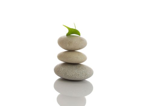 Spa stones and green leaf, isolated on white background.