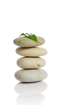 Spa stones and green leaf, isolated on white background.