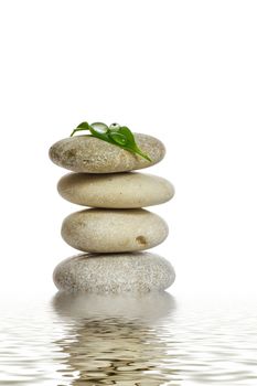 Spa stones and green leaf, isolated on white background.