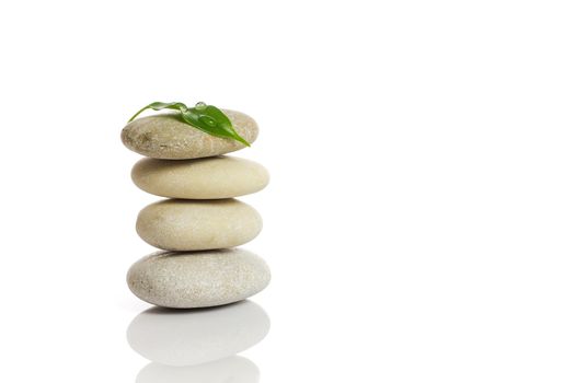 Spa stones and green leaf, isolated on white background.