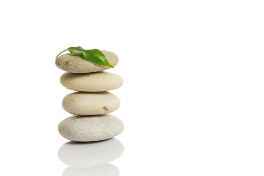 Spa stones and green leaf, isolated on white background.