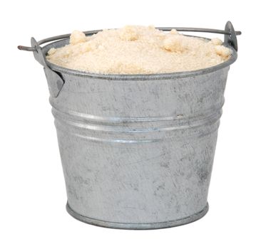 Golden caster sugar in a miniature metal bucket, isolated on a white background