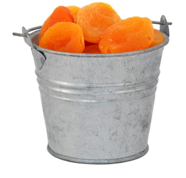 Dried apricots in a miniature metal bucket, isolated on a white background