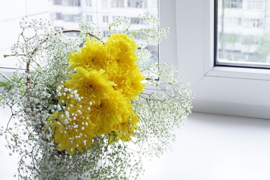 Fresh spring flowers in a vase on a window sill