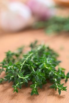 Bundle of fresh thyme with garlic in the back (Selective Focus, Focus on the front of the thyme)