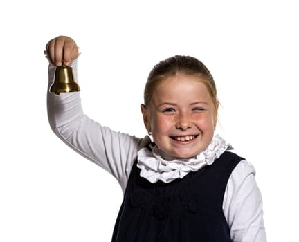 Winking Young school girl ringing a golden bell on white background