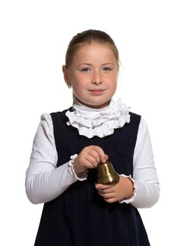 Young school girl ringing a golden bell on white background