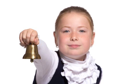 Young school girl ringing a golden bell on white background focused on bell