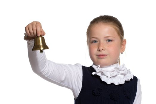 Young school girl ringing a golden bell on white background