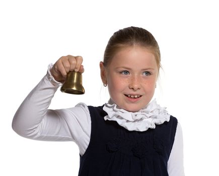 Young school girl ringing a golden bell on white background