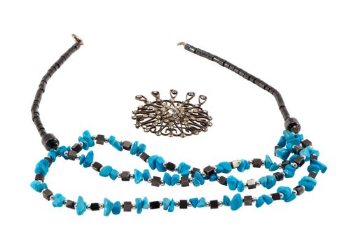 Handmade blue and black bead stone necklace and brooch in center isolated on white.