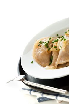 Homemade pierogi or dumpling on white and black plate