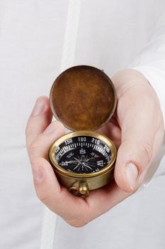Close-up photograph of a man holding an old compass.