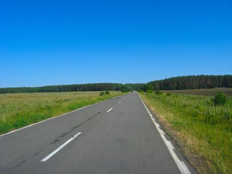 The image of asphalted road and the blue sky