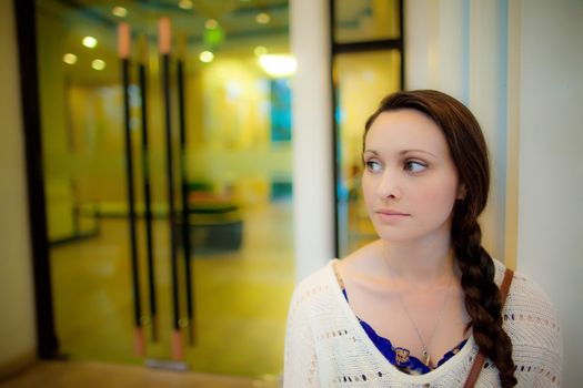 Young caucasian woman close up with plaited hair waiting in front of a hotel for transfer to dinner

