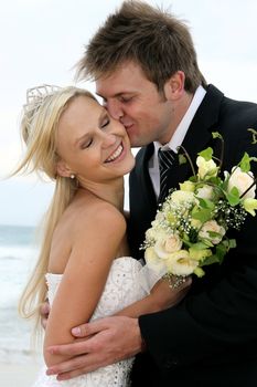 Pretty blond bride and her groom at the sea shore