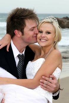 Pretty blond bride and her groom at the sea shore