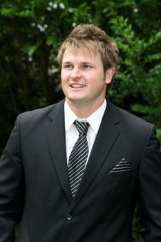 Handsome young bridegroom in a black suit and tie