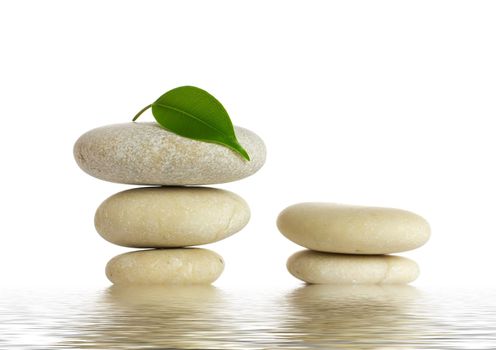 Spa stones and green leaf, isolated on white background.