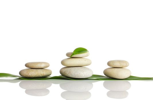 Spa stones and green leaf, isolated on white background.