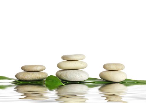 Spa stones and green leaf, isolated on white background.