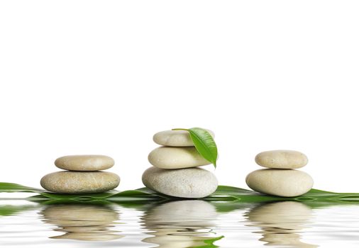 Spa stones and green leaf, isolated on white background.