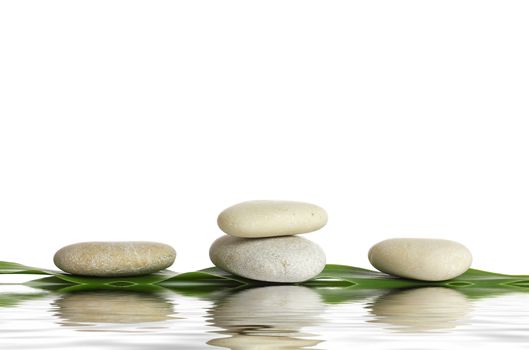 Spa stones and green leaf, isolated on white background.