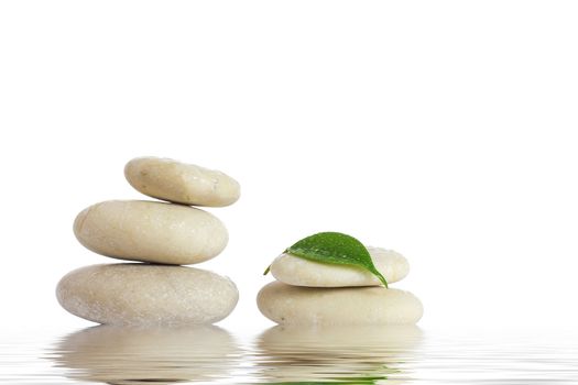 Spa stones and green leaf, isolated on white background.