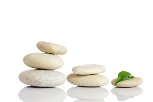 Spa stones and green leaf, isolated on white background.