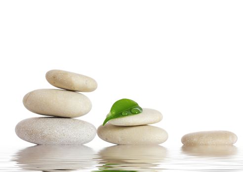 Spa stones and green leaf, isolated on white background.