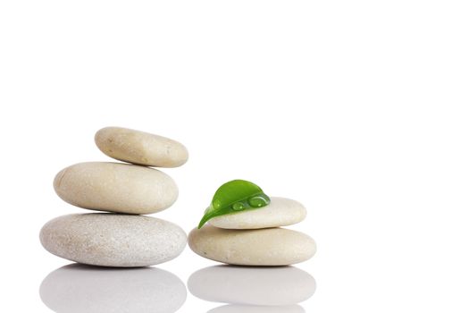 Spa stones and green leaf, isolated on white background.