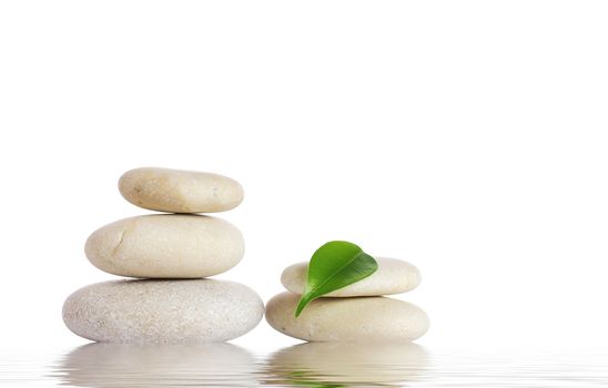 Spa stones and green leaf, isolated on white background.