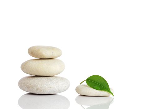 Spa stones and green leaf, isolated on white background.