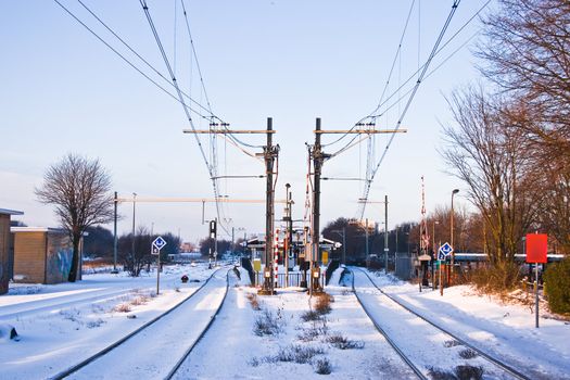 Railroad and railwaystation in winter with first snow and blue sky