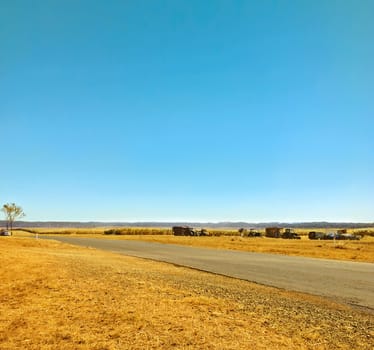 Agriculture rural land harvest time dusty and dry with clear blue sky background