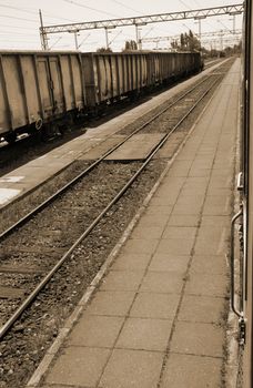 railway with cargo train near the station in sepia