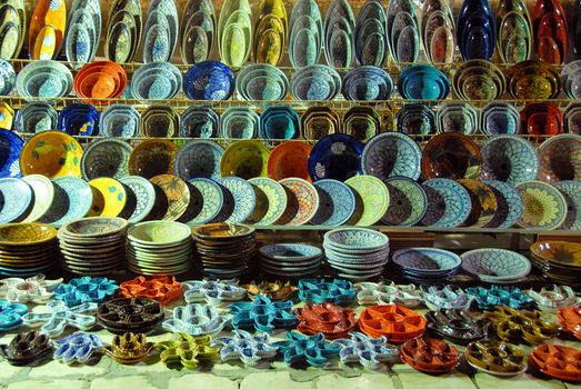 various pottery on shelves of oriental outdoor store in Tunisia at the evening