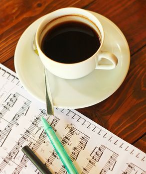 Hot coffee on music note with pen