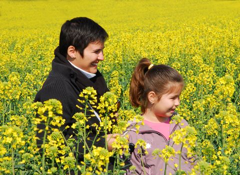 mother and daughter sitting in a yellow field